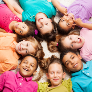 Young children in a circle, with a colorful background.